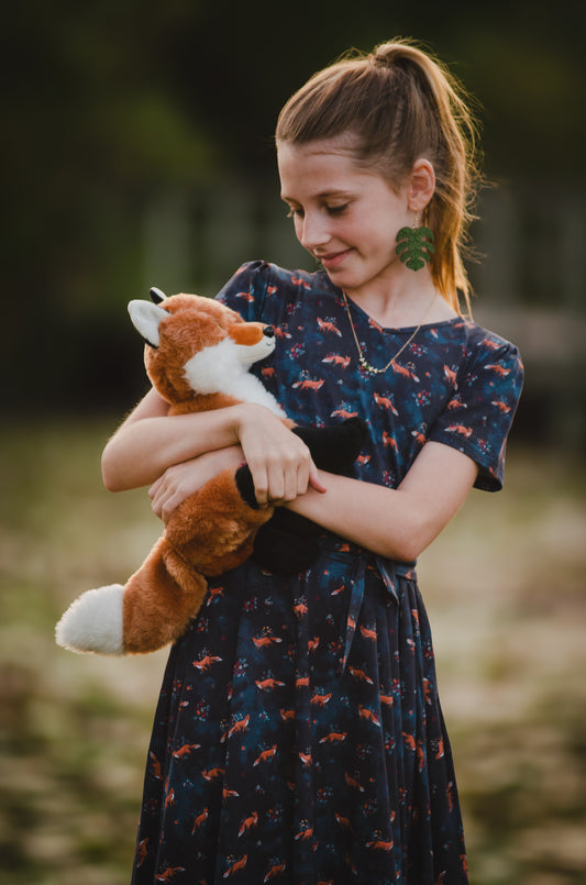 Young girl in modest dress holding stuffed animal