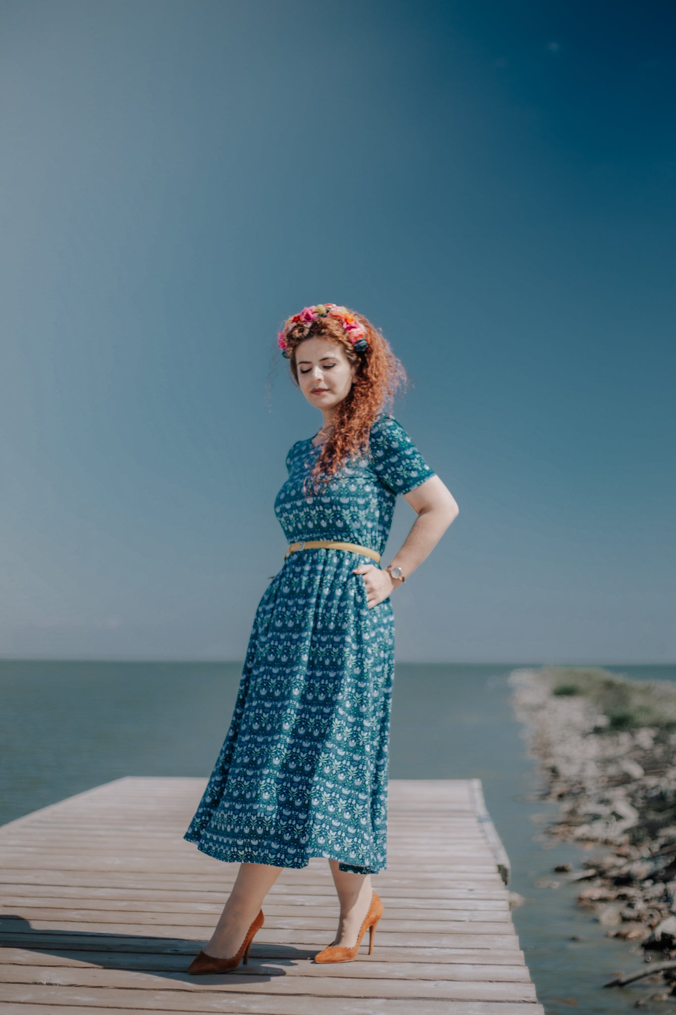Woman in modest nursing dress, standing on dock.