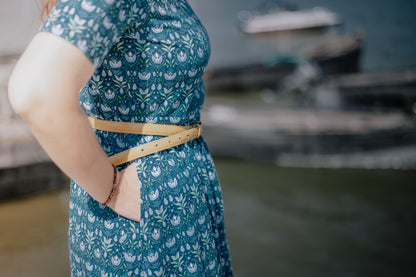 Woman in modest nursing dress, waterfront boats.
